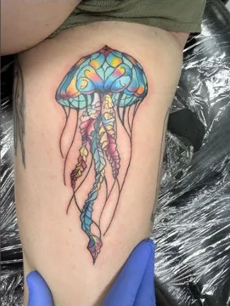 Stained glass style jellyfish tattoo on the thigh